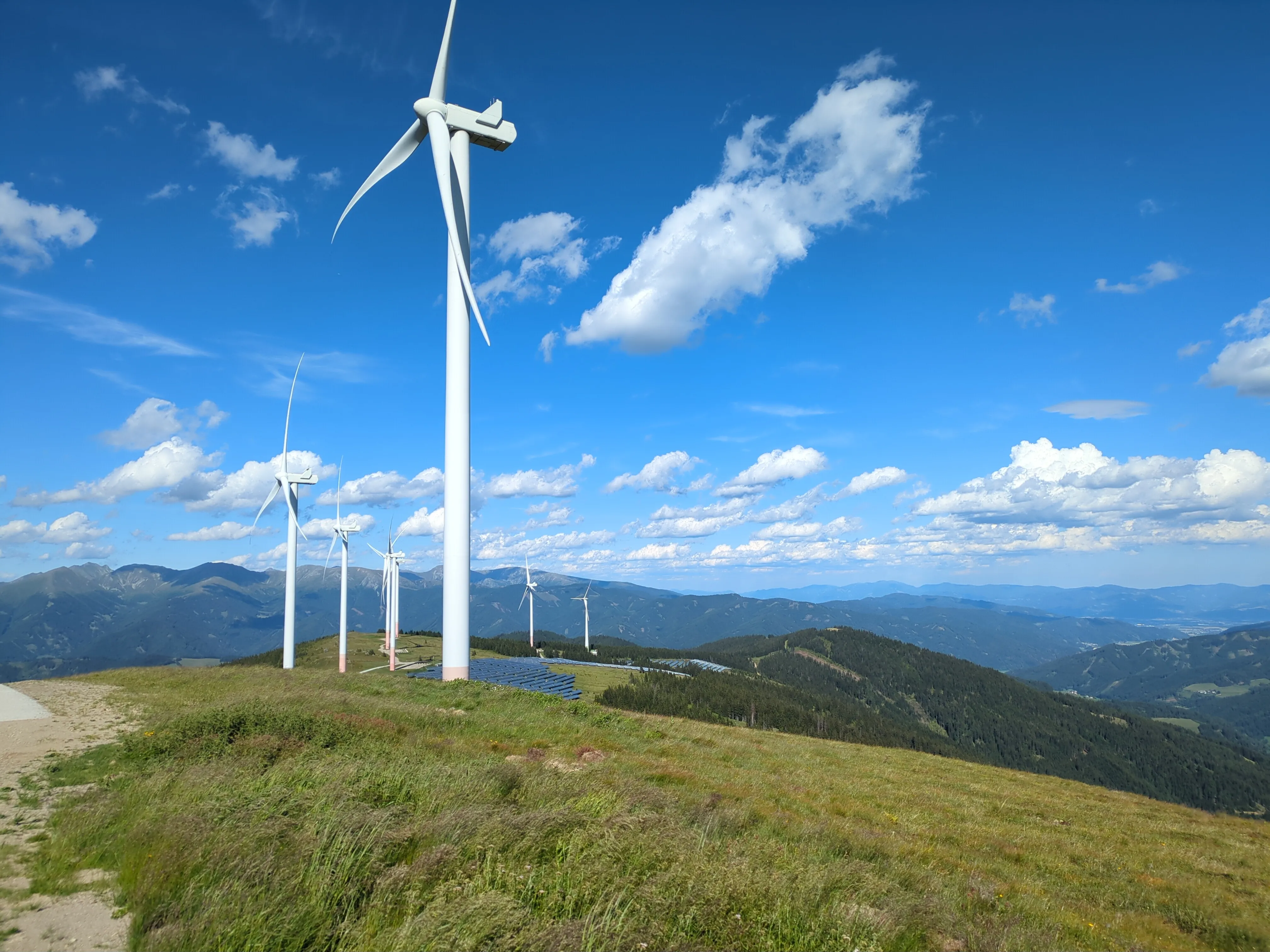 Blick auf 8 der 9 Windräder und Solarmodule. Blick nach Nordosten.